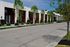 Modern row of stylish townhouses with lush landscaping and inviting patios in an urban setting.