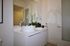 Sleek modern bathroom showcasing a stylish sink with elegant orchid decor and contemporary fixtures.