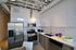 Contemporary kitchen featuring sleek stainless steel appliances, modern cabinetry, and stylish open shelving in a bright, spacious layout.
