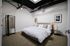 Chic modern bedroom with a plush bed, stylish lighting, and elegant decor, perfect for relaxation.