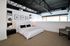 Modern industrial-style bedroom featuring sleek black ceiling beams, elegant wall art, and luxurious bedding, creating a chic and comfortable retreat.