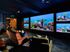 Luxury home theater with plush seating, featuring an impressive wall of vibrant aquariums illuminating the room.