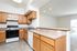 Bright kitchen with sleek wooden cabinets, modern appliances, and a spacious countertop ideal for dining and entertainment.