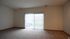 Bright, spacious living area with large windows and plush carpeting, perfect for natural light lovers.