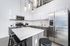 Modern kitchen with sleek stainless steel appliances, elegant pendant lighting, and a spacious island with bar seating.