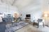 Modern open-concept living space with high ceilings, stylish kitchen with pendant lighting, cozy seating area, and sleek decor.