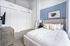 Chic and serene bedroom with modern decor, featuring a plush bed, elegant artwork, and ample closet space.