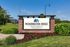 Inviting sign for Pickerington Ridge Apartments surrounded by lush greenery and vibrant flowers, creating a welcoming atmosphere.