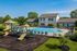 Inviting apartment complex with serene outdoor swimming pool and modern playground, surrounded by lush greenery.