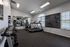 Modern fitness center with treadmills, dumbbells, and a motivational blackboard in a bright, airy room.