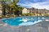 Inviting residential community with a sparkling pool, surrounded by stylish lounge chairs and lush greenery for relaxation and enjoyment.