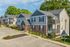 Charming residential apartment complex featuring modern two-story buildings with private balconies, surrounded by lush greenery and ample parking spaces.