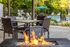 Inviting outdoor patio with cozy fire pit and stylish wicker chairs overlooking a refreshing pool and lush greenery.
