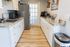 Inviting modern kitchen with sleek countertops, stylish white cabinets, and stainless steel appliances.