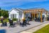 Charming outdoor patio area with cozy seating, a wooden pergola, and lush landscaping, perfect for relaxation and entertaining.