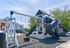 Inviting playground with swings and slides surrounded by charming residential buildings, perfect for family living.