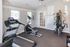Bright and modern gym room equipped with a treadmill, stationary bike, and multi-station fitness machine.