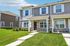 Charming townhouse with modern stone facade and lush green lawn, perfect for family living.