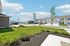 Charming suburban neighborhood view showcasing modern townhouses, manicured lawns, and a bright blue sky.