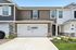Charming townhouse with a modern facade, featuring a double garage and well-maintained front garden.