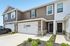 Charming townhouse with modern facade, featuring two stylish entrances and attached garage, set in a serene neighborhood.
