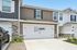 Charming two-story townhouse with elegant stone accents, featuring a spacious two-car garage and modern exterior design.