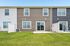 Charming townhouse exterior with clean lines, modern siding, and a lush green backyard perfect for relaxation.