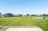 Charming suburban neighborhood with modern homes overlooking a serene pond and lush green lawns, offering a peaceful and inviting community setting.