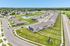 Tranquil suburban community with elegant row homes, lush green lawns, and a serene pond with a fountain, offering a picturesque neighborhood vibe.