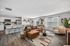 Modern open-concept living space featuring a stylish kitchen with white cabinetry, cozy brown sofa, and inviting dining area, perfect for entertaining and relaxation.