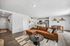 Inviting open-plan living space featuring a modern kitchen with sleek stainless steel appliances, a cozy brown sectional sofa, and a stylish dining area perfect for entertaining.