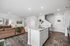 Chic open-concept living area features a modern kitchen with island, cozy living room with stylish decor, and elegant hardwood floors.
