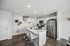 Modern kitchen showcasing sleek white cabinetry, stainless steel appliances, and an inviting breakfast bar with stylish stools.