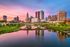 Breathtaking waterfront cityscape showcasing modern architecture at sunset, reflecting vibrant colors on the river.