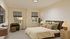 Inviting bedroom with a cozy bed, stylish green armchair, and warm lighting, perfect for relaxation.