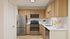 Modern kitchen with sleek stainless steel appliances, warm wooden cabinets, and elegant white countertops, creating a stylish and inviting culinary space.