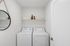 Chic laundry room with modern washer and dryer, stylish shelving, and elegant decor accents.
