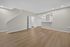 Bright open-concept living space with modern wood flooring, inviting neutral walls, and a cozy kitchen area.