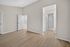 Bright and spacious bedroom with elegant wooden flooring and modern neutral tones, featuring a connected bathroom and ample closet space.