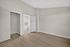 Bright and spacious bedroom with elegant wooden flooring, a sleek open closet, and modern white doors, perfect for creating a cozy, minimalist retreat.