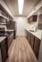 Contemporary kitchen with sleek stainless steel appliances, elegant dark wood cabinets, and stylish wood laminate flooring.
