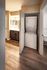 Convenient in-unit laundry area with a modern washer and dryer, adjacent to a stylish bathroom with elegant wood flooring.