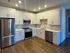 Modern kitchen with sleek stainless steel appliances, elegant white cabinetry, and stylish subway tile backsplash.