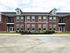 Charming brick apartment building with modern windows and accessible parking, perfect for comfortable living.
