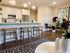 Elegant open-concept kitchen with sleek white cabinets, vibrant pendant lighting, and cozy wooden bar stools, perfect for modern living.