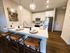 Charming kitchen with modern stainless steel appliances, elegant pendant lighting, and a stylish breakfast bar with seating.