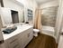 Elegant bathroom with modern fixtures, featuring a sleek vanity, plush towels, and stylish tile accents.