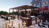 Luxurious outdoor terrace featuring a stylish pergola, modern seating, a double grill station, and giant chess set, perfect for entertaining and relaxation.