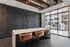 Chic modern dining area with elegant pendant lighting, leather bar stools, and a large window view.