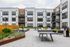 Modern apartment community with stylish facade, lush landscaped courtyard, and inviting outdoor seating area.